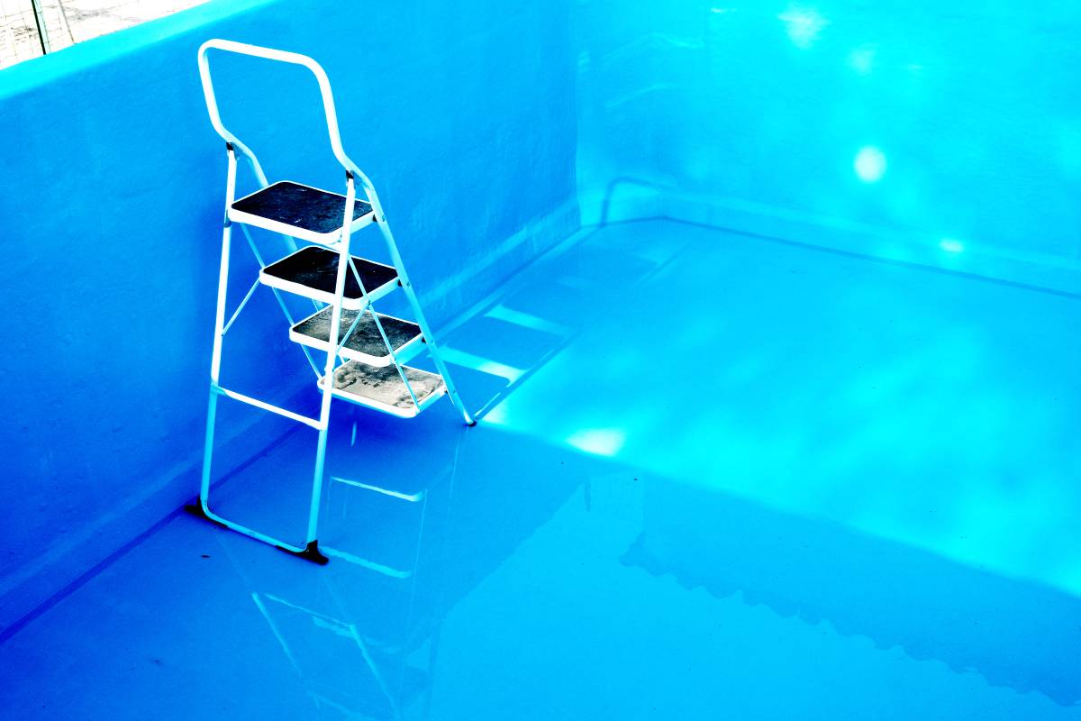 White iron ladder into a blue painted pool.